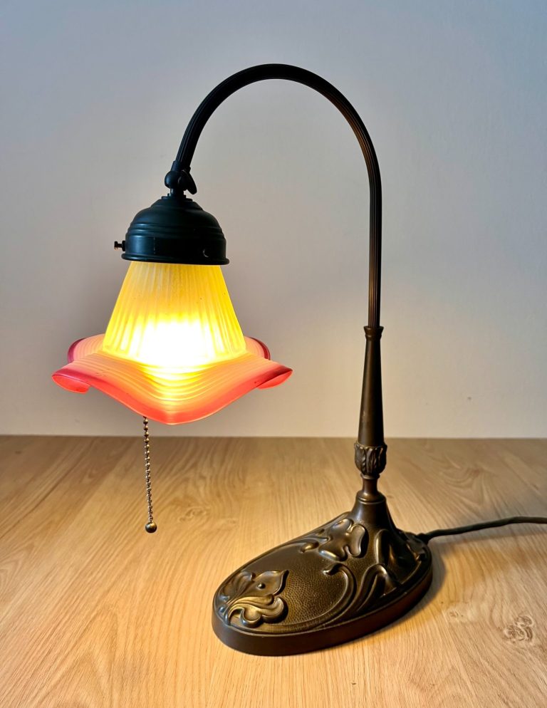 Art Nouveau Floral Glass Desk Lamp, c. 1920 Art Nouveau desk lamp with bronze base, curved stem, and floral pink-green glass shade, early 20th century